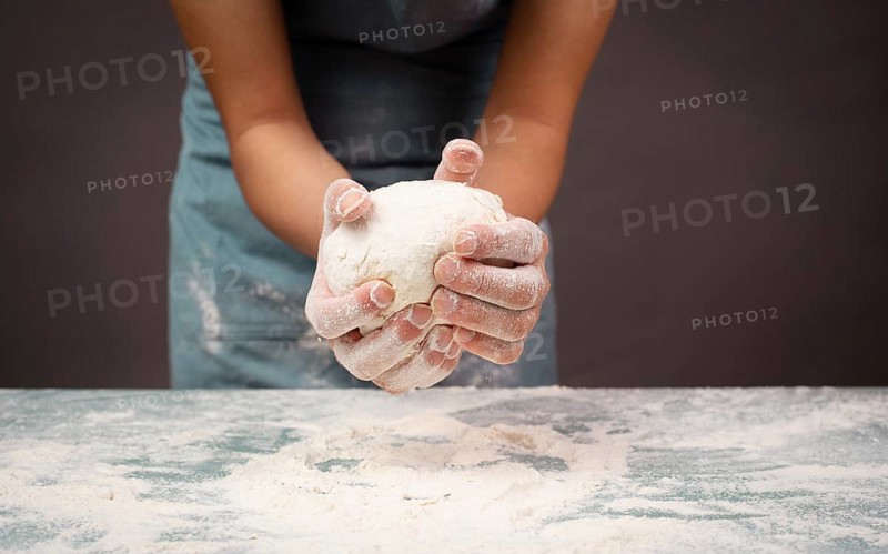 Baker kneading dough for pizza or artisan bread with his hands, prepare ingredients for food, baking pastry