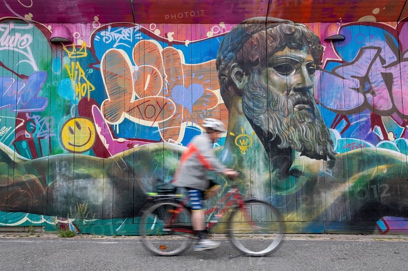 God of Greek mythology, Zeus, large graffiti on building fence, cyclist, harbour, Gothenburg, Västra Gotalands län province, Sweden, Europe
