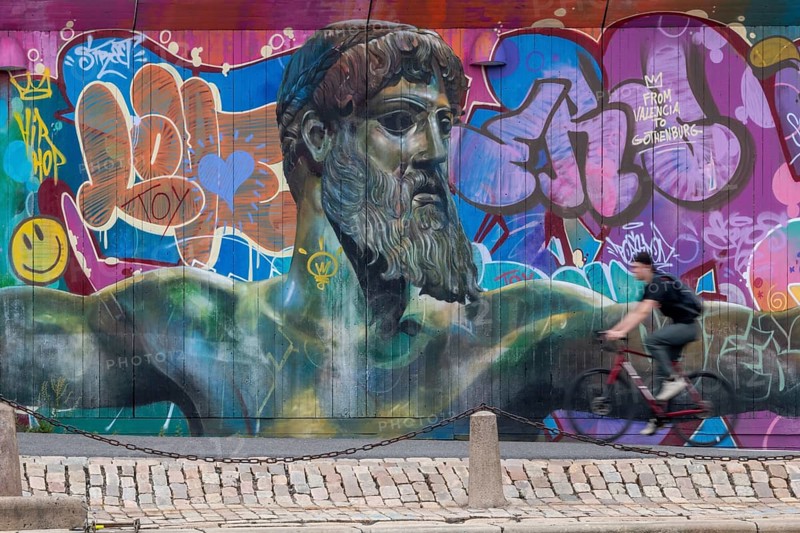 God of Greek mythology, Zeus, large graffiti on building fence, cyclist, harbour, Gothenburg, Västra Gotalands län province, Sweden, Europe