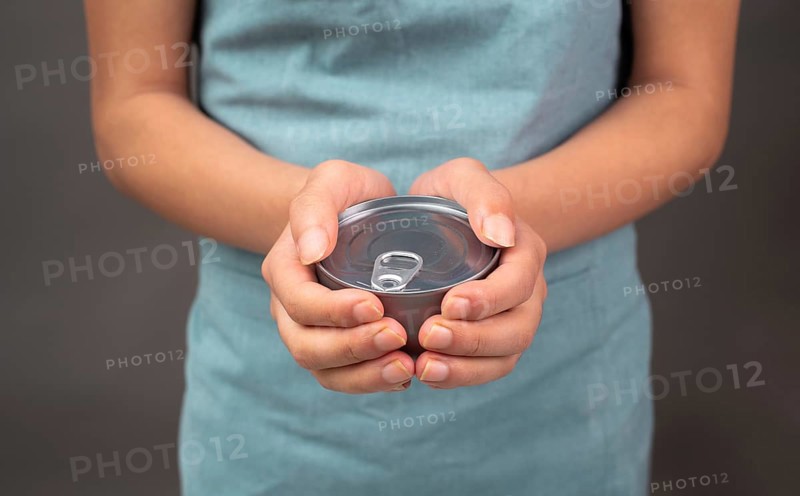 Holding a tin can with preserved food, box with tuna fish, processed ingredients, feeding a pet