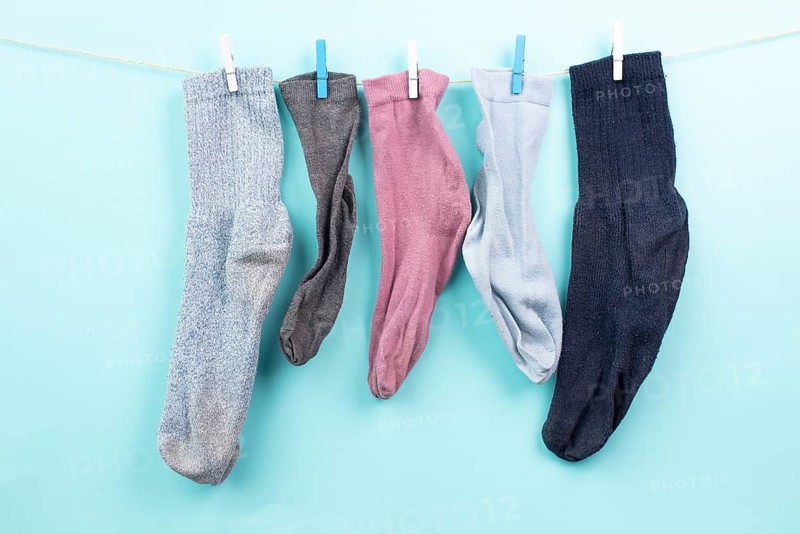 Lost socks hanging on a clothes line with clothespin, missing sock match after washing, memorial day
