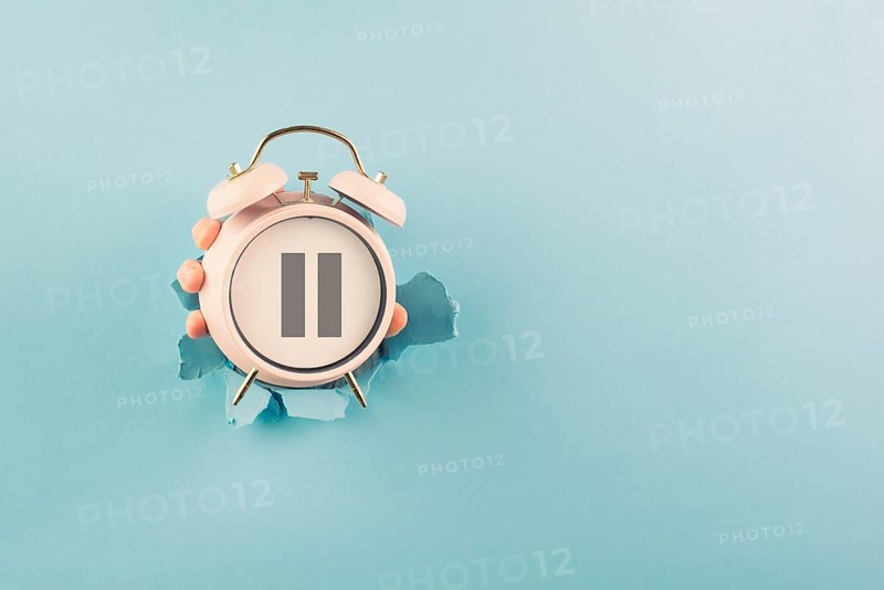 Alarm clock with pause sign, take a break, menopause concept, hormone replacement therapy