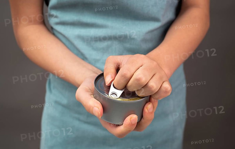 Opening a tin can with preserved food, box with tuna fish, processed ingredients, feeding a pet
