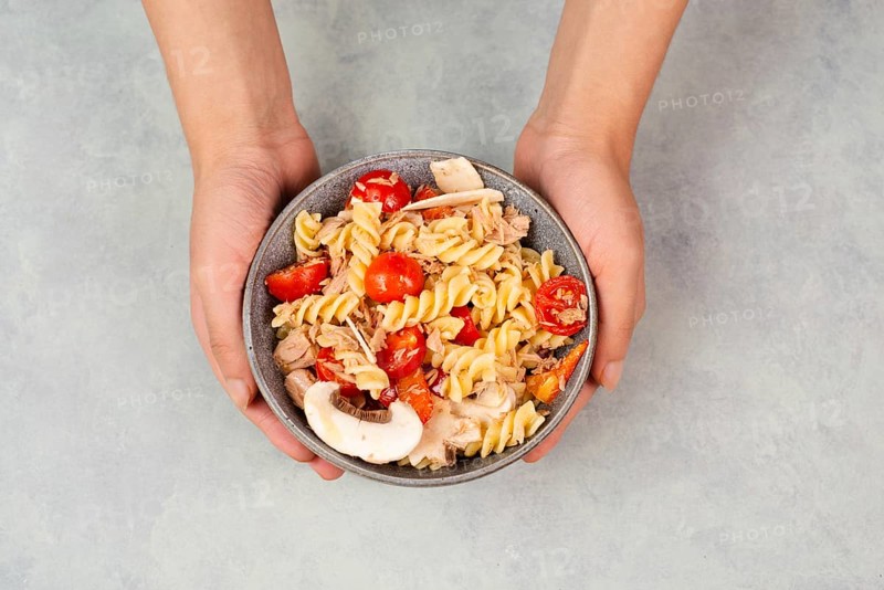 Pasta salad in a bowl, sliced mushroom, tomato, red pepper pieces and tuna, healthy food with vegetables, fresh organic nutrition