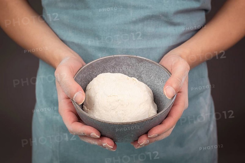 Fresh wheat dough, baker holds bowl with flour, bread or pizza, prepare ingredients for food, baking pastry