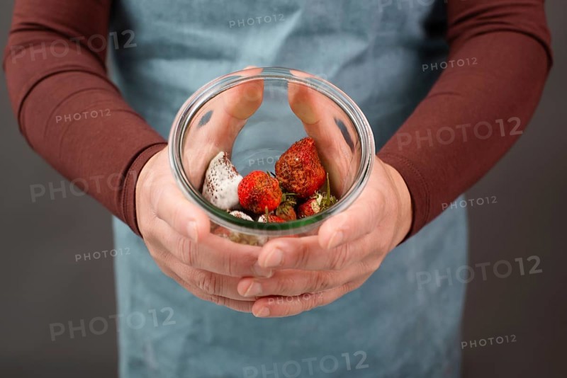 Moldy strawberry fruits with spot fungus in a jar, rotten strawberries, decomposition of the food