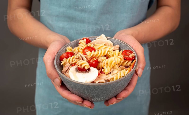 Pasta salad in a bowl, sliced mushroom, tomato, red pepper pieces and tuna, healthy food with vegetables, fresh organic nutrition
