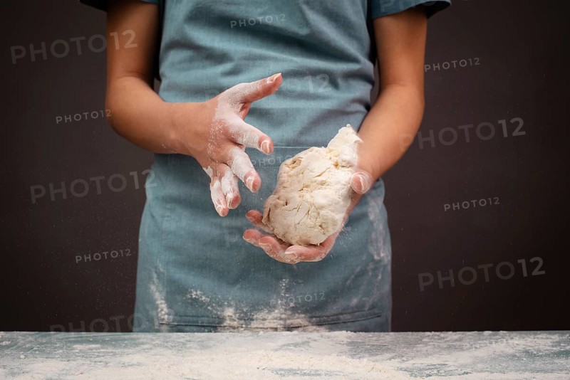 Baker kneading dough for pizza or artisan bread with his hands, prepare ingredients for food, baking pastry