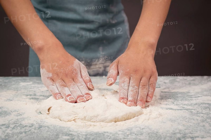 Baker kneading dough for pizza or artisan bread with his hands, prepare ingredients for food, baking pastry