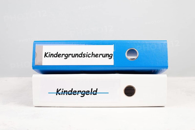 Basic child benefit stands in german language on the file folder, new payment regulation for family in Germany, social issue