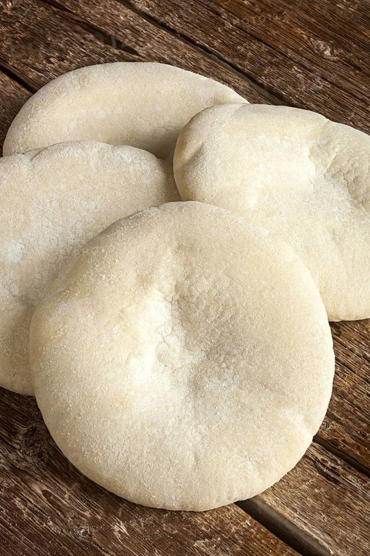 Four loaves of Arabic bread on the wooden table