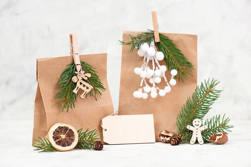 Christmas holiday gift bags for suprise, fir branches, gingerbread man, elk, snow covered berries and nuts, blank tag with copy space