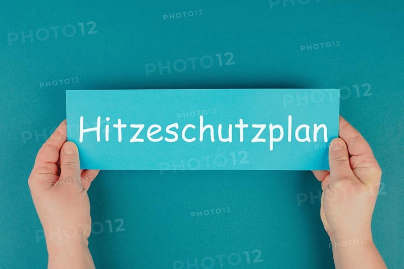 Heat protection plan stands in german language on the paper, regulation for warm summer days, climate change and global warming, extreme temperature