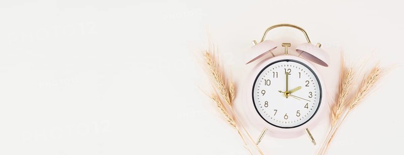 Alarm clock with wheat, end of daylight saving time in autumn, winter time changeover
