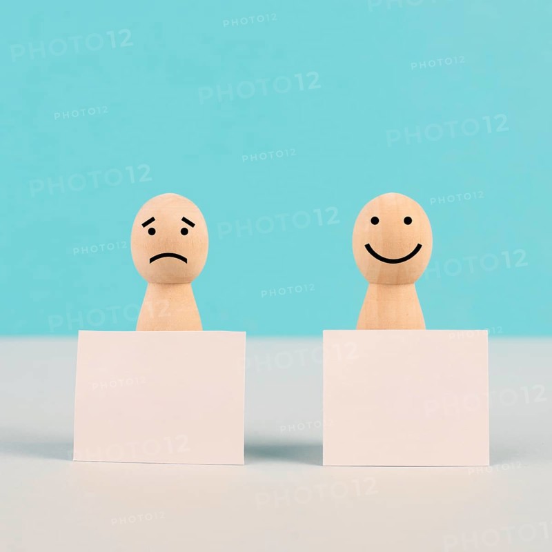 Man with a sad and a happy face holding empty signs, positive and negative mindset, support and evaluation, emotion and mental health