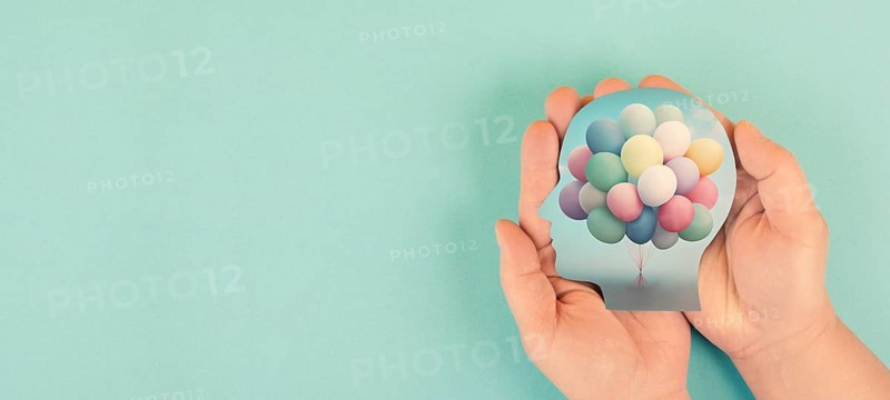 Hands holding head, brain with colorful ballons, self care, freedom and mental health concept, positive thinking, creative mind