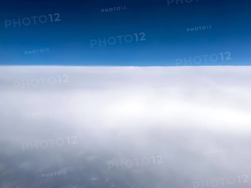 Aerial view View from high altitude 35000 feet around 10700 metres 11 kilometres from above on closed cloud cover of Altostratus clouds, above blue sky, international