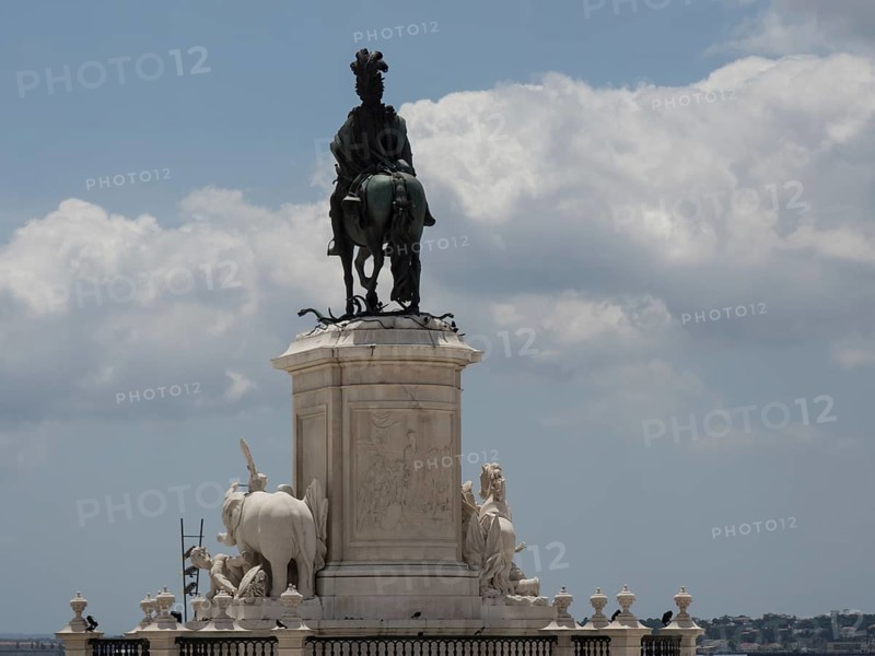 An impressive marble equestrian statue stands on a decorative pedestal under a cloudy sky, Lisbon, Portugal, Europe