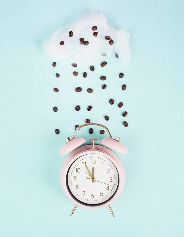 Wake up, time for a coffee break, alarm clock with roasted beans raining from a cloud