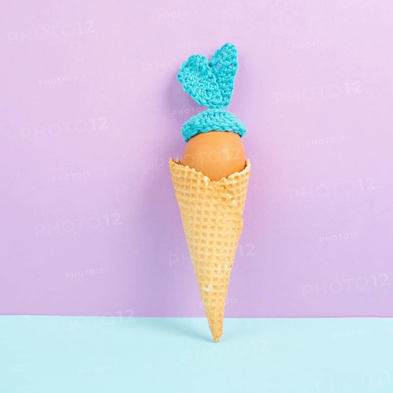 Cute easter bunny or rabbit with an egg face in an ice cream cone, spring holiday, greeting card