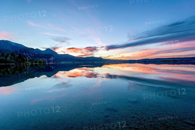 Lake Kochel with reflection of sun and clouds at sunset, calm water, in the background the mountains Heimgarten, Stein, Rötelstein, Hohentanne, Hirschberg, Bromberg and Kreuzbichl, Kochel am See, Bavarian Prealps, Alps, Upper Bavaria, Bavaria, Germany, Europe