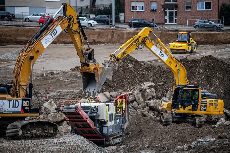 Construction site, processing of a building site, shredding of building rubble, excavators fill concrete and other building rubble into the crushing plant, shredder, which then turns it into small stone, building material recycling, Essen, North Rhine-Westphalia, Germany, Europe
