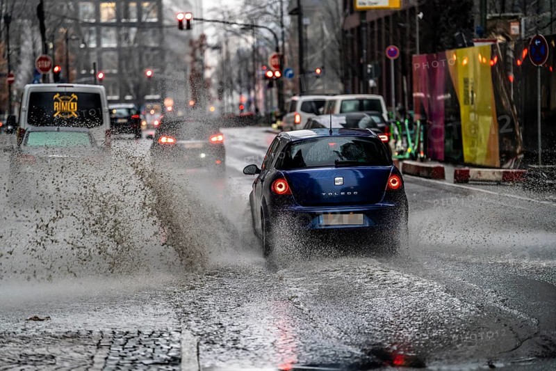Winter, rainy weather, freezing rain, large puddle, puddle of water, in the city centre, Grosse Gallusstrasse, vehicles driving through, spraying water fountains, Frankfurt am Main, Hesse, Germany, Europe
