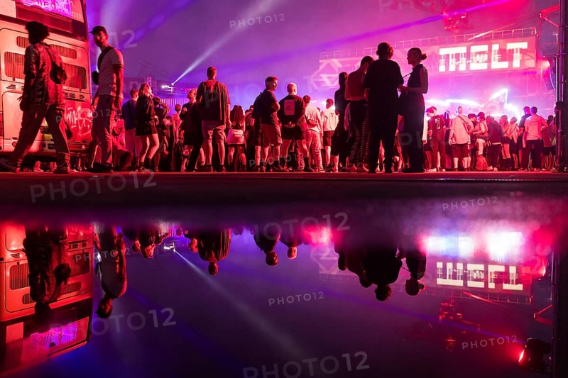 Festival visitors are reflected in a puddle at the Melt Festival in Ferropolis on 12 July 2024. After a total of 27 years, the festival will take place for the last time in 2024