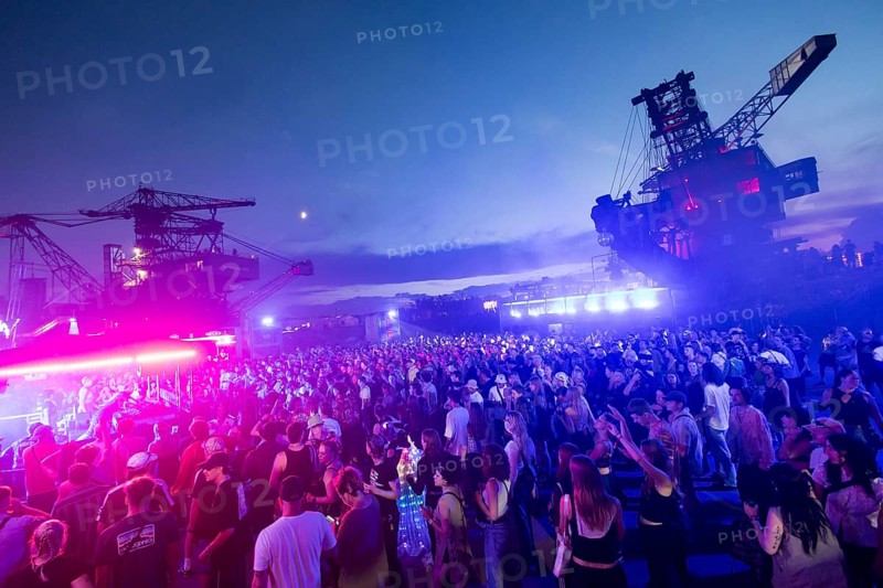 Festival visitors celebrate between excavators at the Melt Festival in Ferropolis on 12 July 2024. After a total of 27 years, the festival will take place for the last time in 2024