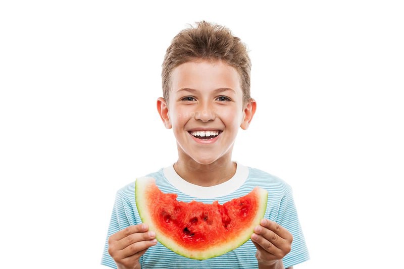 Handsome smiling child boy hand holding red ripe watermelon fruit food slice white isolated