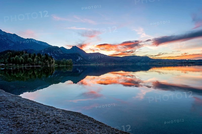 Lake Kochel with reflection of sun and clouds at sunset, calm water, in the background the mountains Heimgarten, Stein, Rötelstein, Hohentanne, Hirschberg, Bromberg and Kreuzbichl, Kochel am See, Bavarian Prealps, Alps, Upper Bavaria, Bavaria, Germany, Europe