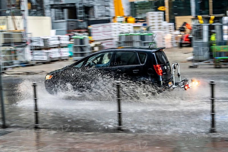 Winter, rainy weather, freezing rain, large puddle, puddle of water, in the city centre, Grosse Gallusstrasse, vehicles driving through, spraying water fountains, Frankfurt am Main, Hesse, Germany, Europe
