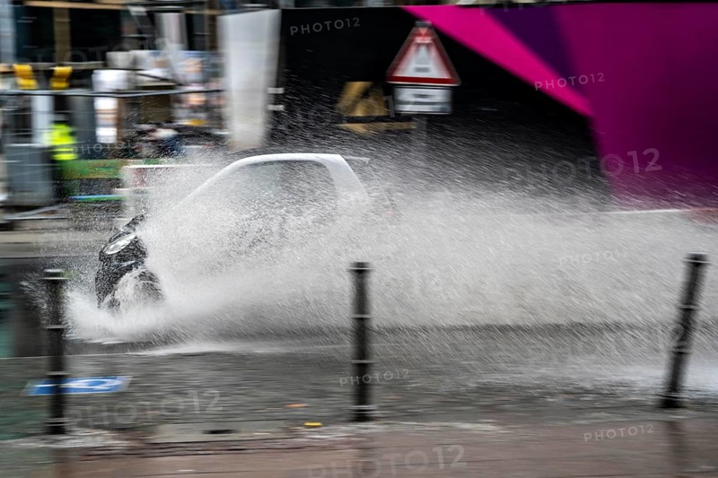 Winter, rainy weather, freezing rain, large puddle, puddle of water, in the city centre, Grosse Gallusstrasse, vehicles driving through, spraying water fountains, Frankfurt am Main, Hesse, Germany, Europe