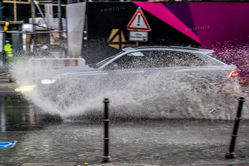 Winter, rainy weather, freezing rain, large puddle, puddle of water, in the city centre, Grosse Gallusstrasse, vehicles driving through, spraying water fountains, Frankfurt am Main, Hesse, Germany, Europe