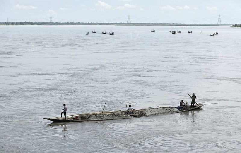 Labourer carries extracted sand from Beki River, in Barpeta district in Assam, India on Sunday September 2, 2018. Sand extraction from rivers, essential for construction and infrastructure, significantly impacts the environment by destroying aquatic habitats, increasing riverbank erosion, degrading water quality, depleting groundwater, and altering natural flow patterns