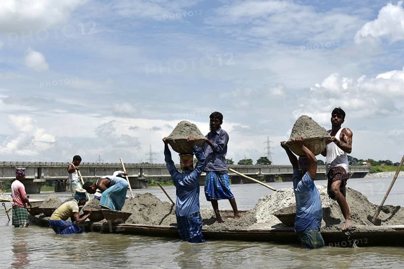 Labourer carries extracted sand from Beki River, in Barpeta district in Assam, India on Sunday September 2, 2018. Sand extraction from rivers, essential for construction and infrastructure, significantly impacts the environment by destroying aquatic habitats, increasing riverbank erosion, degrading water quality, depleting groundwater, and altering natural flow patterns