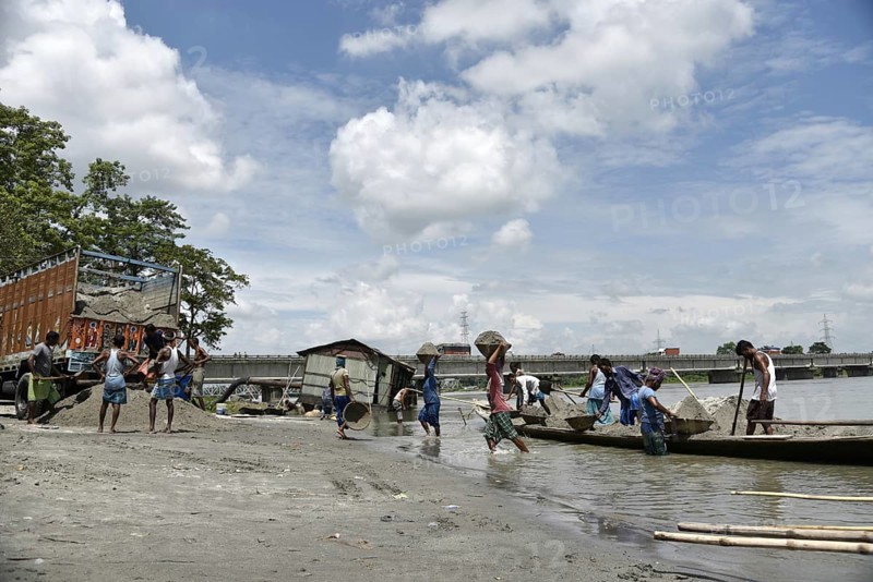 Labourer carries extracted sand from Beki River, in Barpeta district in Assam, India on Sunday September 2, 2018. Sand extraction from rivers, essential for construction and infrastructure, significantly impacts the environment by destroying aquatic habitats, increasing riverbank erosion, degrading water quality, depleting groundwater, and altering natural flow patterns