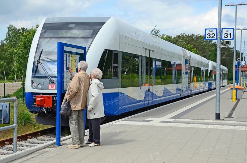 Two people look at the tour list at the local trains that serving Stralsund in Germany and Swinoujscie in Poland at platform in Swinoujscie, Swinemünde, West Pomerania, Poland, Europe