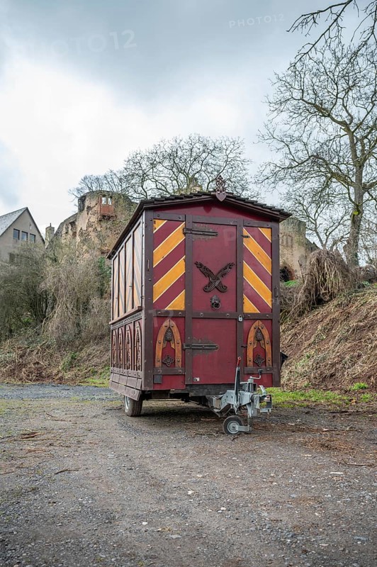 Decorative Trailer made of wood, Christmas market stand on a trailer in front of an old castle, Ronneburg Castle, Germany, vertical shot, Europe