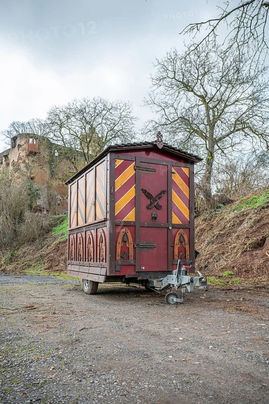 Decorative Trailer made of wood, Christmas market stand on a trailer in front of an old castle, Ronneburg Castle, Germany, vertical shot, Europe