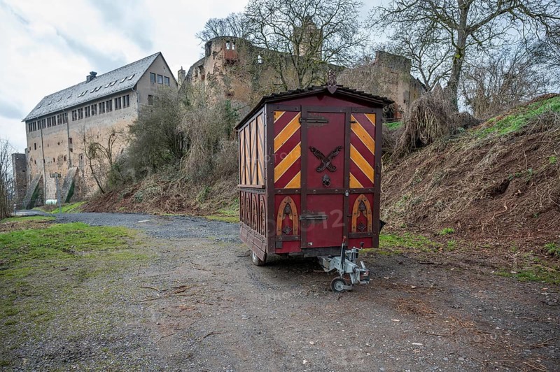 Decorative Trailer made of wood, Christmas market stand on a trailer in front of an old castle, Ronneburg Castle, Germany, Europe