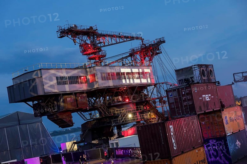 Opencast mining excavators behind containers at the Melt Festival in Ferropolis on 12 July 2024. After a total of 27 years, the festival will take place for the last time in 2024