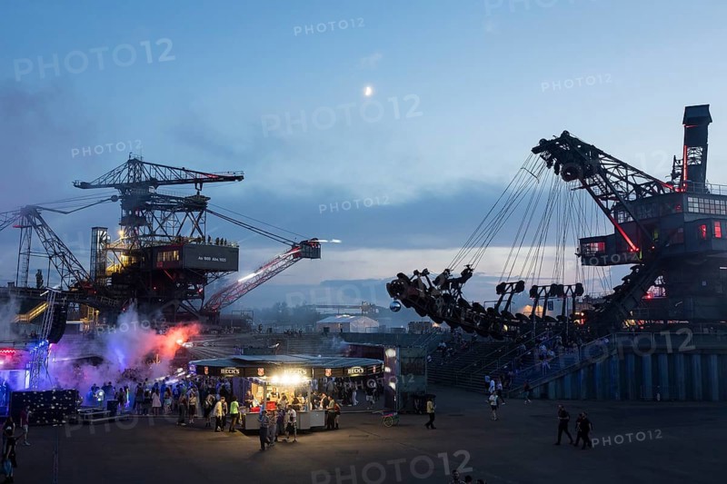 Evening atmosphere with festival visitors and beer stand between excavators at the Melt Festival in Ferropolis on 12 July 2024. After a total of 27 years, the festival will take place for the last time in 2024