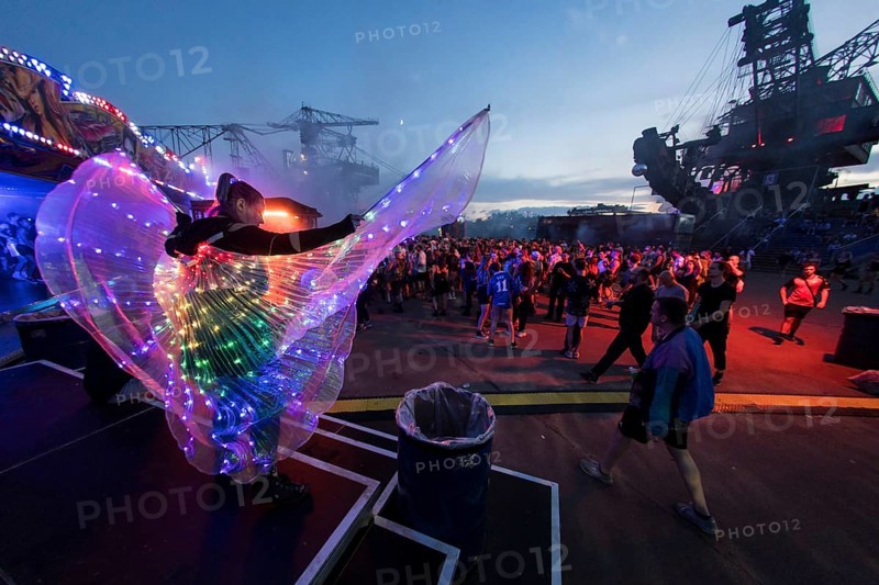 Festival visitor with a bright dress between excavators in the evening at the Melt Festival in Ferropolis on 12 July 2024. After a total of 27 years, the festival will take place for the last time in 2024