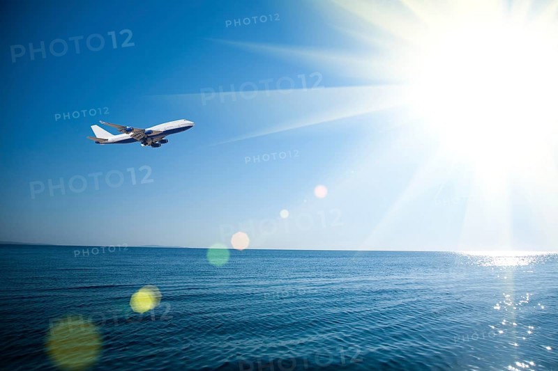 Airplane flying over the sea. Vacations concept