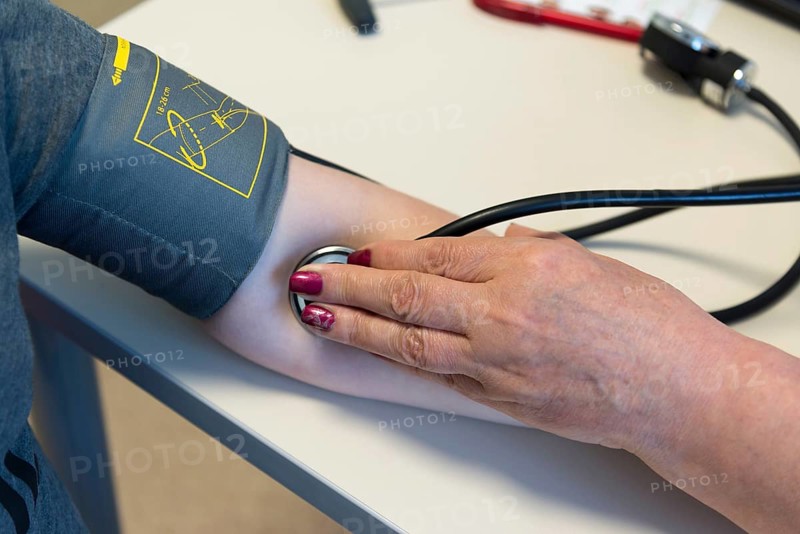 The doctor measures pressure at a teenager