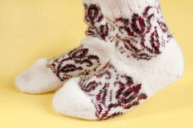 Children's feet in wool socks on a yellow background