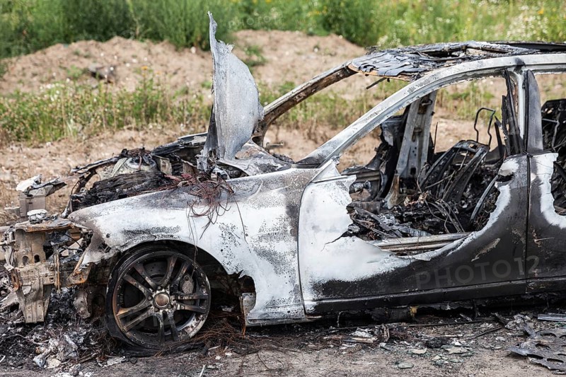 Road wreck accident or arson fire burnt wheel car vehicle junk