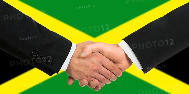 The Jamaica flag and business handshake