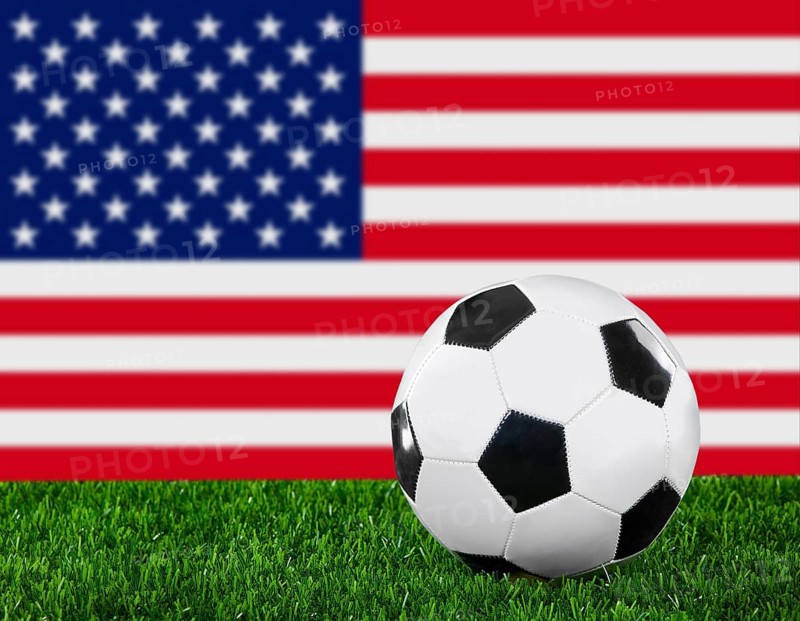 The USA flag and soccer ball on the green grass